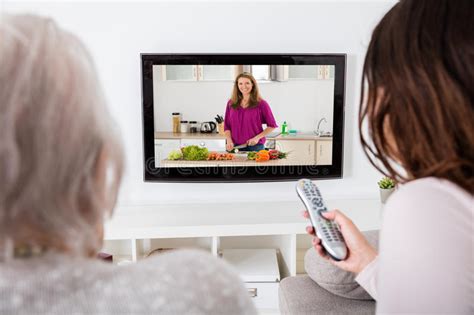 Two Women Watching Cooking Show On Television Stock Image