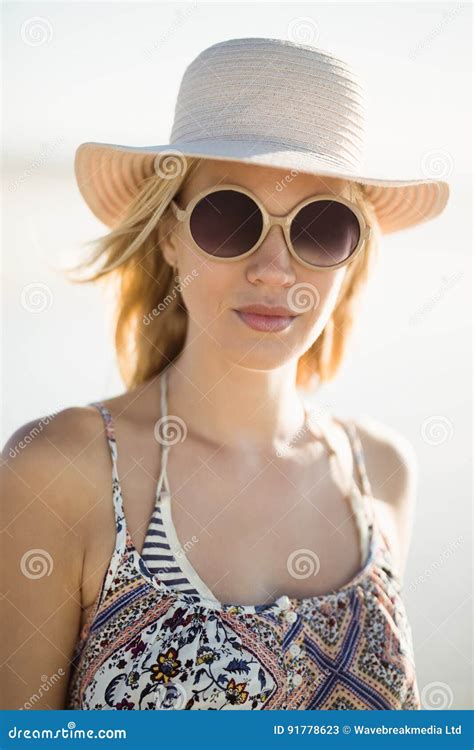 retrato de las gafas de sol que llevan y del sombrero de la mujer joven en la playa imagen de