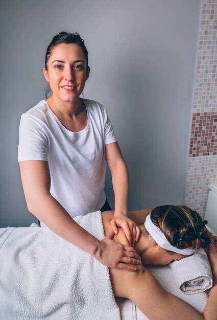 Premium Photo Portrait Of Smiling Female Massage Therapist Doing Relaxing Massage On Shoulders