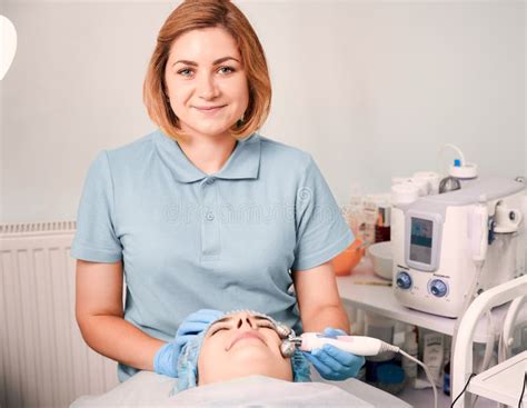 Cheerful Beautician Massaging Woman Face With Facial Roller Stock Image Image Of Lifting