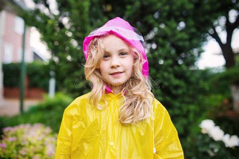 Outdoor Photo Of Little Blonde Girl In Yellow Raincoat Stock Image