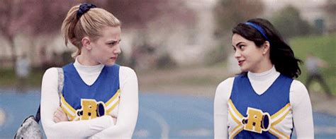 two girls in cheerleader uniforms standing next to each other