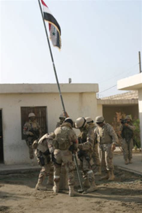 Soldiers From The Iraqi Special Forces Raise The Iraqi National Flag In