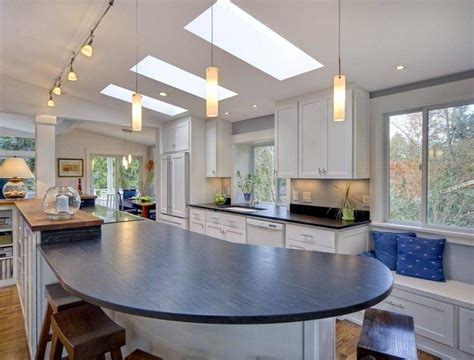 Large country style kitchen with a vaulted ceiling with a single beam, pendant lighting and hardwood flooring, along with a center island with a breakfast bar. 15 Collection of Pendant Lights for Vaulted Ceilings
