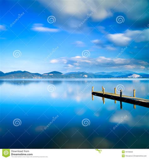 Wooden Pier Or Jetty And On A Blue Lake Sunset And Sky