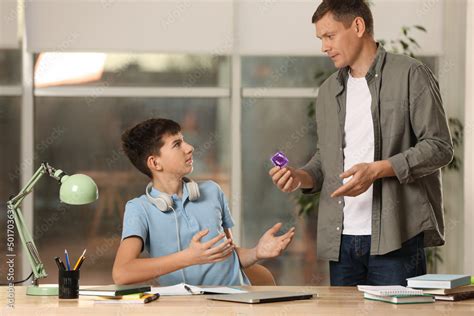 Father Talking With His Teenage Son About Contraception While He Doing Homework At Home Sex
