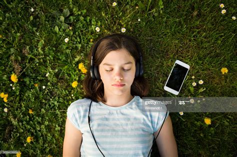 Portrait Of Girl Lying On Meadow Listening Music With Headphones And Music Photography