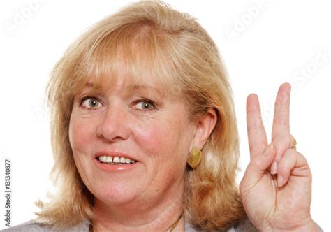 Mature Woman Holding Up Two Fingers In Victory Sign Buy This Stock