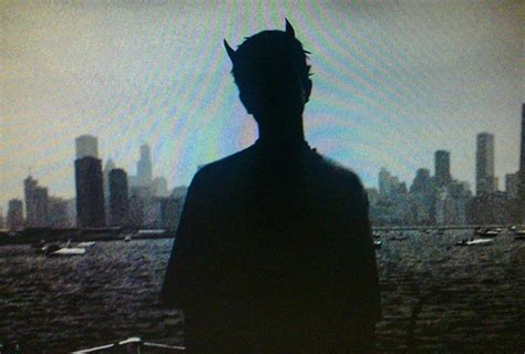 The Silhouette Of A Man Standing In Front Of A Cityscape With Sun Beams