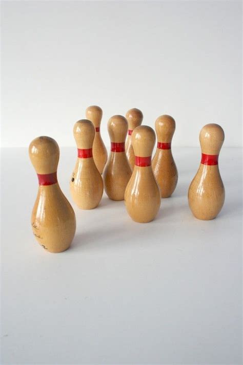 Several Wooden Bowling Pins Lined Up In A Row On A White Surface With