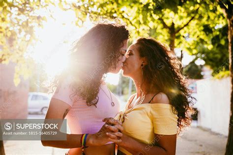 Romantic Lesbians Kissing While Standing In City On Sunny Day Superstock