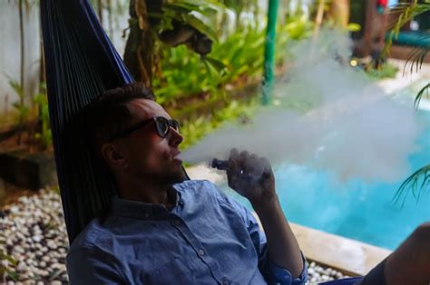 해먹에 쉬고 전자 담배에서 증기를 버리는 남자 담배에 대한 스톡 사진 및 기타 이미지 담배 해변 흡연 Istock