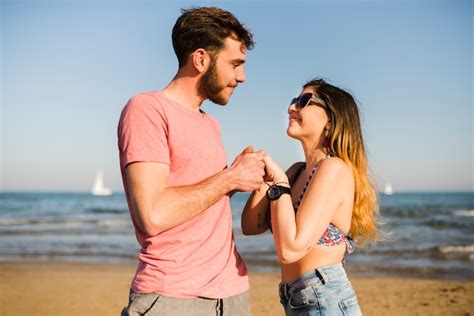Free Photo Loving Couple Holding Each Other S Hand Standing At Beach