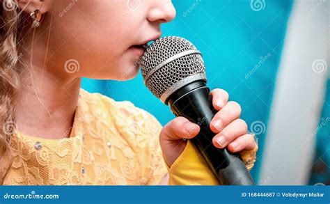 Girl Holding A Microphone In Her Hand Near Her Mouth Stock Image