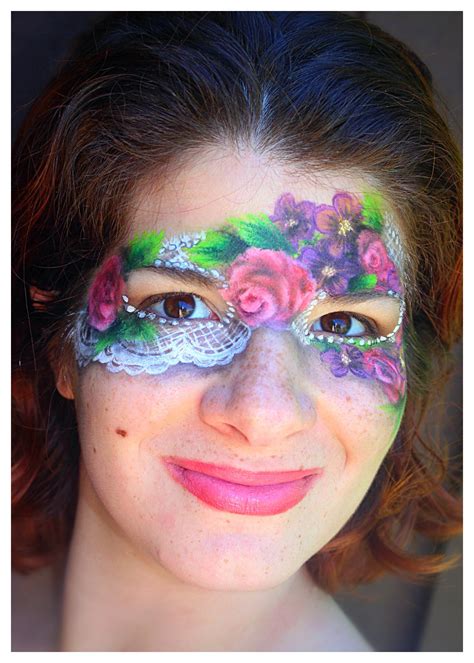 A Woman With Face Paint And Flowers On Her Face