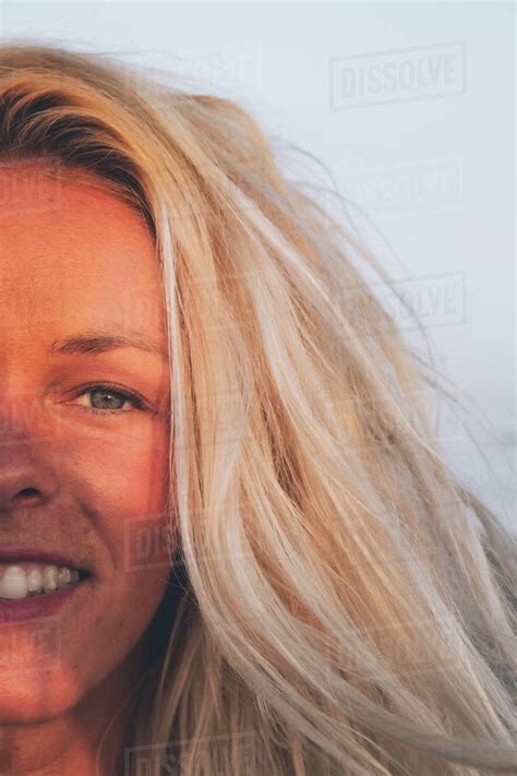 Closeup Of Positive Babe Lady With Blond Hair Standing In Sunlight And Looking At Camera While