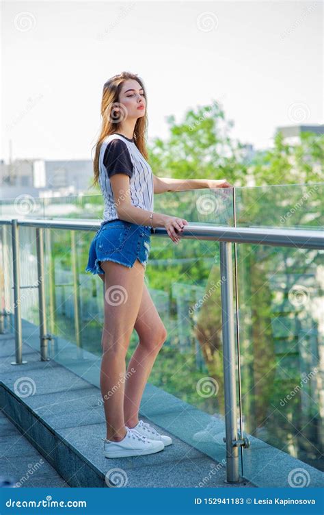 Girl In Shorts On The Balcony In A Cafe Summer Portrait Of Young