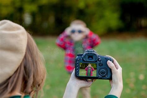Woman Photographer Photographing The Child To Spend Outside In The Park