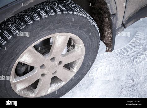 Modern Automotive Wheel With Studded Tires And Winter Snowy Road Stock