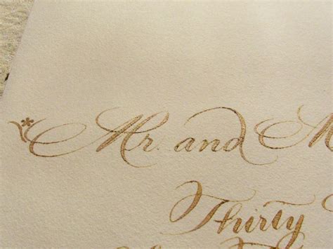 Close Up Of Elegant Hand Crafted Calligraphy In Gold Ink The First