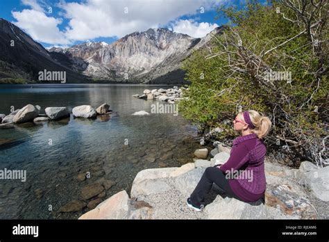 Blond Female Sits Alone By Convict Lake In The Springtime Located Off