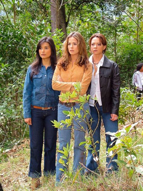 Three Women Standing In The Woods Looking At Something