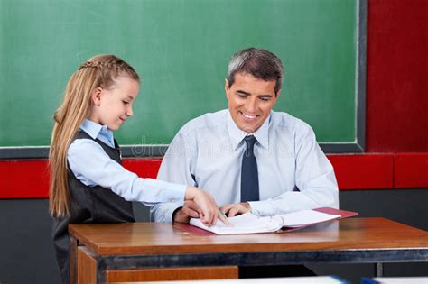 Girl Asking Question To Male Teacher At Desk Stock Image Image Of