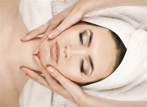 Portrait Of Young Woman Receiving Facial Massage At Day Spa
