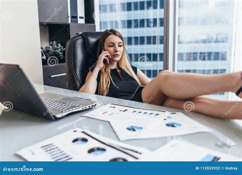 Confident Female Chief Executive Talking On Phone While Sitting With