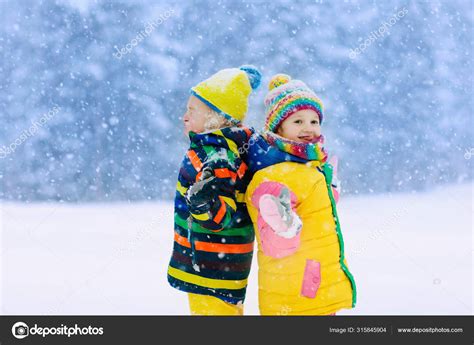 Kids Playing In Snow Children Play In Winter Stock Photo By