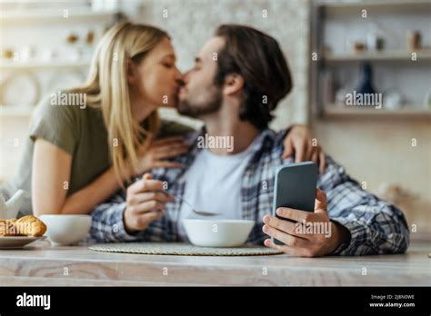 Happy Caucasian Millennial Blonde Wife Kisses Husband With Stubble Guy