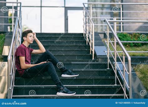 Dreaming Guy In Earphones Holds A Mobile Phone In Hands Relaxing