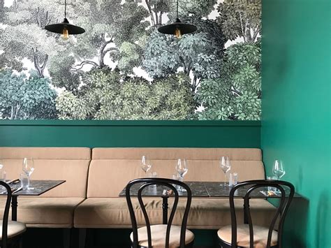 A Restaurant With Green Walls And Black Chairs