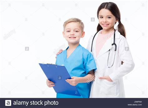 Cute Little Kids In Medical Uniform Playing Doctors And Smiling At