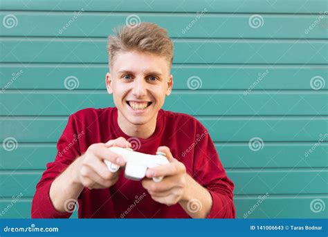 Gamer With A Gamepad In His Hands Plays A Console On A Turquoise