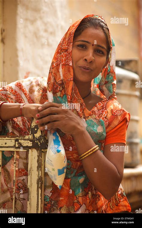indische frau in hellen sari tragen beutel milch jaisalmer rajasthan indien stockfotografie