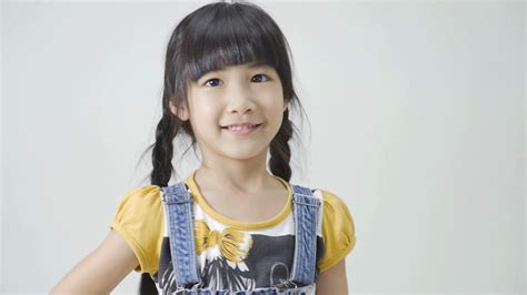 Little Asian Girl Is Smiling On White Background Stock