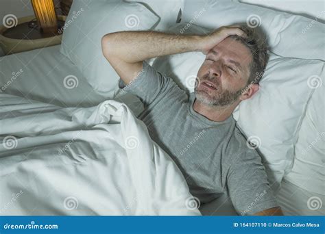 Dramatic Portrait Of Stressed And Frustrated Man In Bed Awake At Night