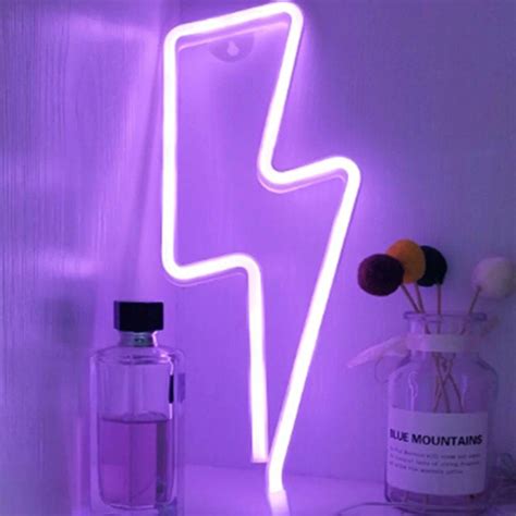 A Purple Neon Sign Sitting On Top Of A Shelf Next To A Bottle And Vase