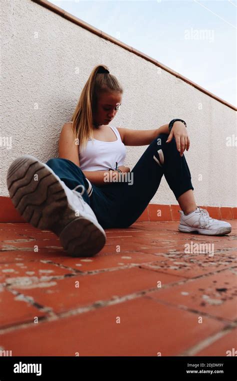 Full Length Of Woman Sitting On Floor Against Wall Stock Photo Alamy