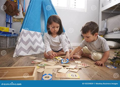 Two Children Playing Number Puzzle Game Together In Playroom Stock