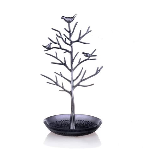 A Metal Tree With Birds Sitting On Its Branches In A Black Bowl