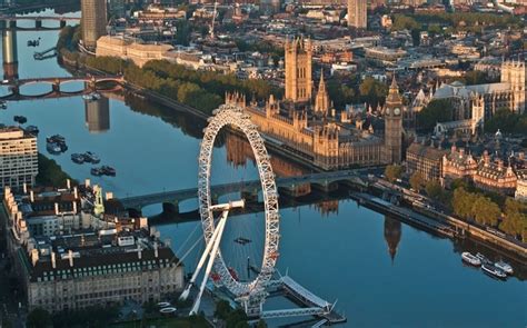 The Houses Of Parliament Are Reflected In The Thames Behind The London