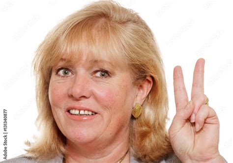 Mature Woman Holding Up Two Fingers In Victory Sign Stock Photo Adobe