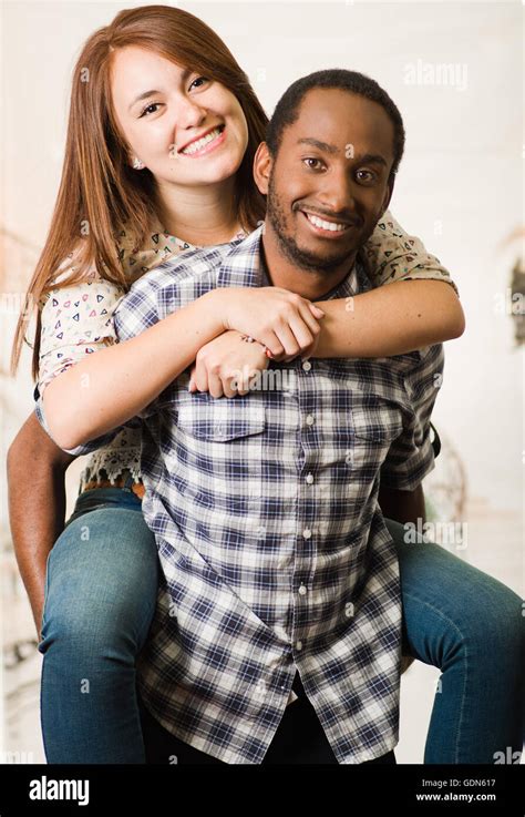 Interracial Couple Wearing Casual Clothes Interacting Having Fun Man Carrying Woman On His Back