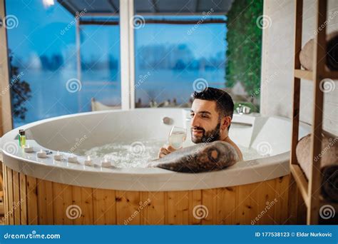 Man Relaxing At Home In The Hot Tub Bath Ritual With A Glass Of Wine