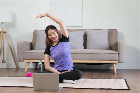 Premium Photo Young Asian Woman Watching Fitness Video On Laptop To Training And Doing