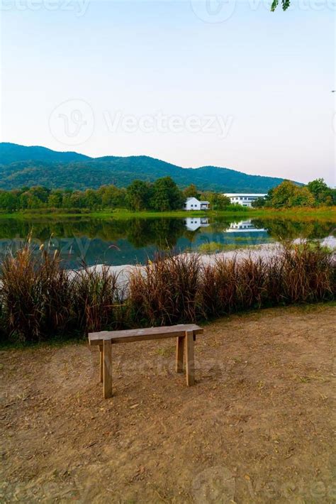 Wood Bench With A Beautiful Lake At Chiang Mai With Forested Mountain