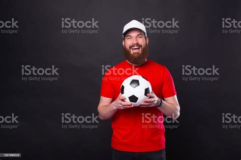 Portrait Of Smiling Happy Young Man Holding Soccer Ball And Looking At