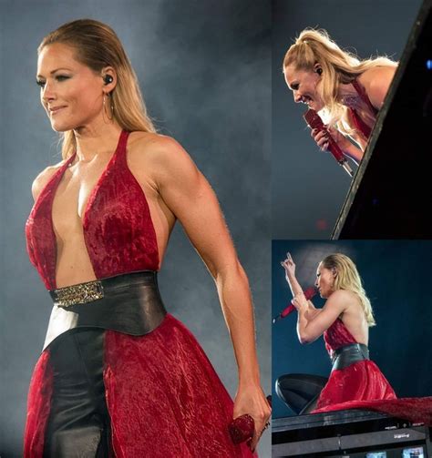A Woman In A Red And Black Dress On Stage With Her Hands Out To The Side